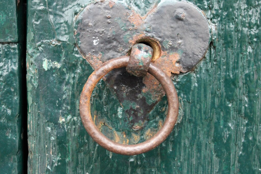 Close-up foto van een oude deurklink op een oude deur.